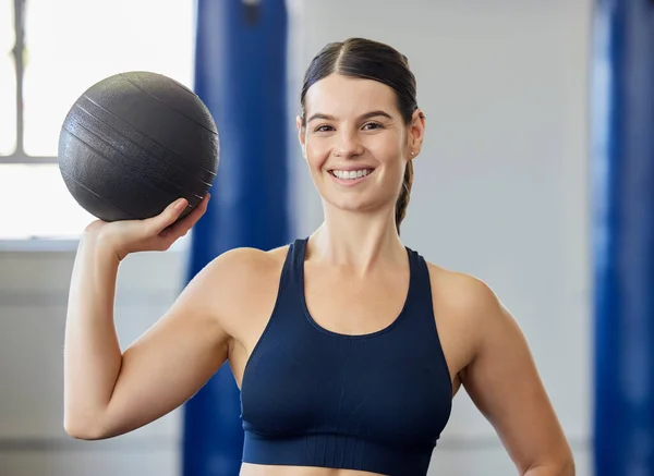 Sports, training and woman with a medicine ball for exercise, fitness and body goal at gym. Portrait of happy, healthy and athlete with a smile for workout for wellness at club for health and cardio.