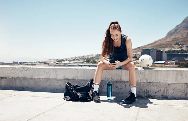 体育妇女 电话和足球或足球锻炼在城市建筑屋顶休息或休息与5G网络服务的应用或社交媒体 女运动员在户外运动后带球 — 图库照片