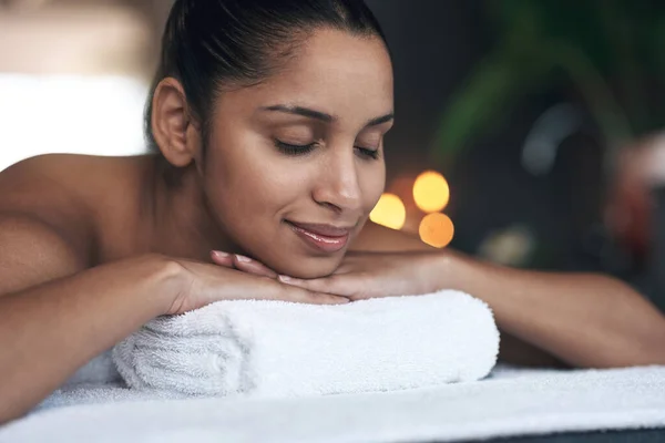 The spa feels as close to experiencing heaven. a young woman lying on a massage bed at a spa