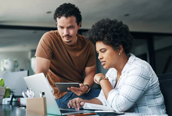 Lets see what we can do about that. two young businesspeople working together in an office