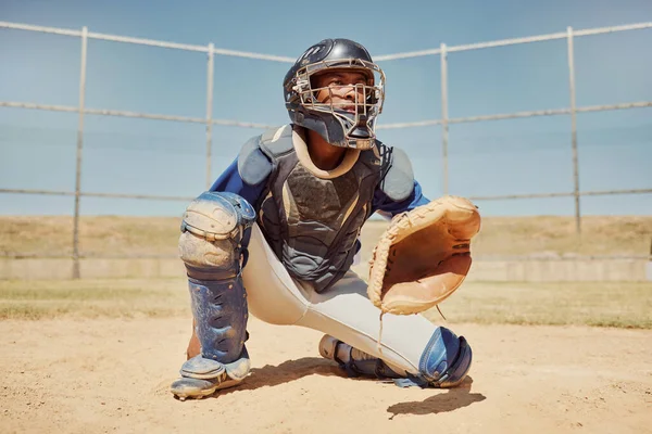 Baseball, sports and man waiting on a field during a game, competition or training. Athlete catcher playing a sport with focus for exercise and fitness in nature or a park at an event in summer.