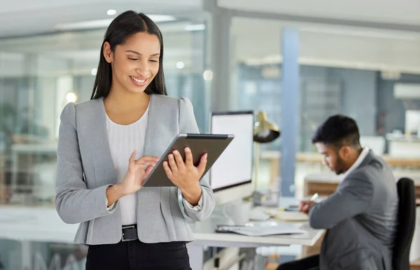 Achieving big things with little devices. a young businesswoman using a digital tablet in a modern office