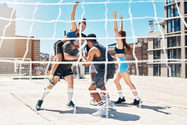 Soccer friends, winner team and game celebration for rooftop sports competition, achievement and success through outdoor goal post. Happy, excited and urban football players group celebrate champions.