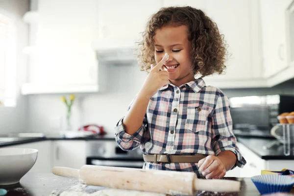 Curiosity calls on all ages. a playful little girl having fun while baking in the kitchen at home