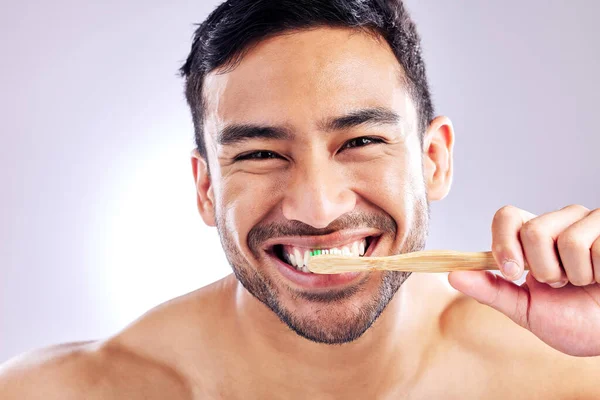 空洞を防ぐために 定期的にブラシする必要があります スタジオショットのハンサムな若い男の歯をブラッシング — ストック写真