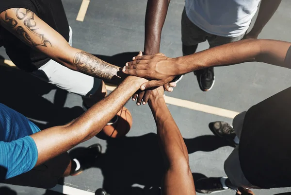 Hands, team and basketball in support, trust and coordination above for unity on the outdoor court. Hand of people in sports teamwork piling together for motivation and collaboration to win game.