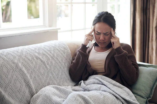 Migraines are a killer to deal with. a young woman experiencing a headache while feeling sick at home