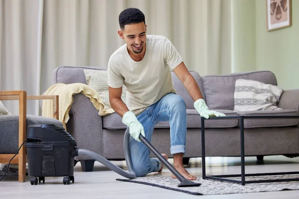 This vacuum gets the job done. a young man vacuuming at home