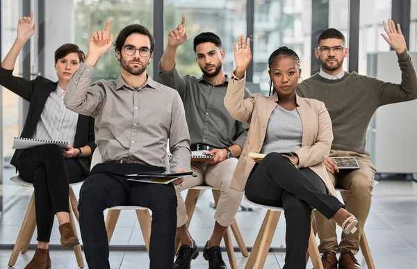 Divided is the one who dances. a group of businesspeople raising their hands during a conference in a modern office