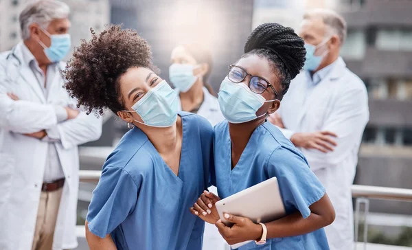 The future of healthcare is in their hands. two young female doctors using a digital tablet in the city