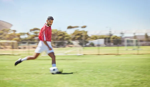 Football, running and soccer man with a ball doing a sport exercise, workout and training. Speed, action and young male athlete in a sports team uniform run a fitness cardio on a grass field.