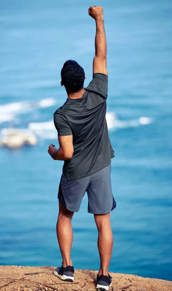 健康和自由是主要目标 后视镜拍摄的是一个年轻的健美男子 他伸展双臂站在海滨锻炼 — 图库照片