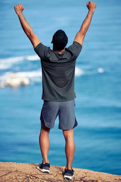 我是冠军 后视镜拍摄的是一个年轻的健美男子 他伸展双臂站在海滨锻炼 — 图库照片
