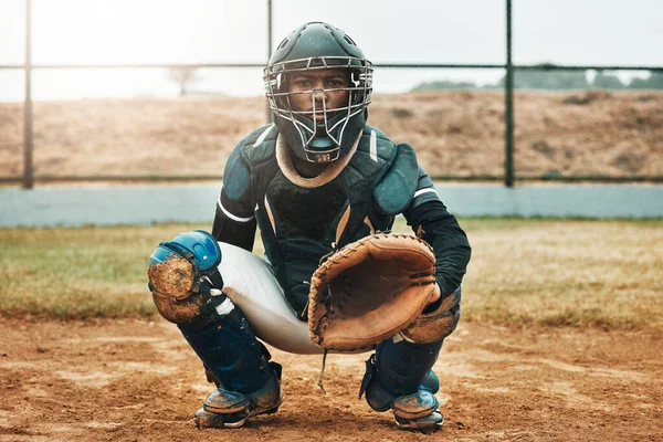 Baseball, catcher and sports with man on field at pitchers plate for games, fitness and health in stadium park. Helmet, glove and uniform with athlete training for workout, achievement and exercise.