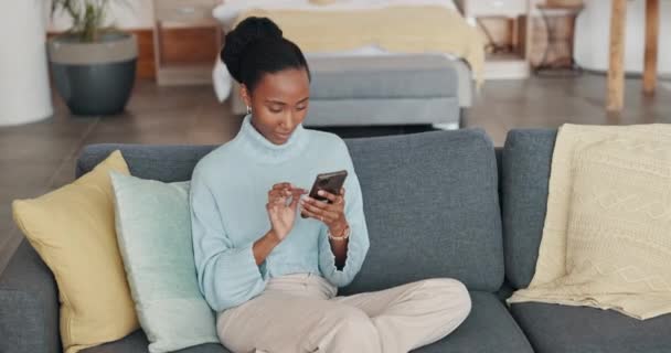 好消息 快乐的黑人女人在客厅沙发上看书 利用在线技术 在室内沙发上与来自纽约的人约会的应用程序 互联网和网页滚动 — 图库视频影像