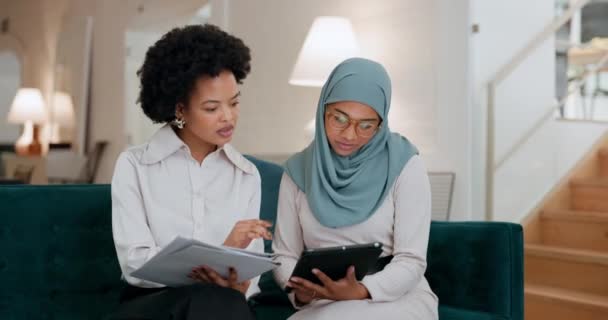 タブレット チームワーク オフィスの同僚と話すイスラム教徒のビジネス女性との出会い イスラム教 インターネット 仕事でソファの上で女性従業員と働く黒人女性とのコラボレーション — ストック動画