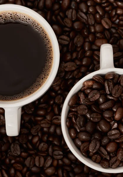 コーヒーは私のサバイバルジュースです コーヒー豆に囲まれた2杯のコーヒーのクローズアップ — ストック写真