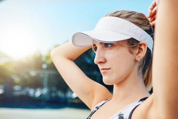 时刻盯着奖品看一个把头发绑在网球场上的年轻女子 — 图库照片