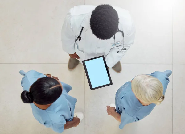 Topview of doctors, tablet green screen and nurses mockup of hospital for patient healthcare with professional consultation. Digital health report, medical diagnosis and consulting colleagues at work.