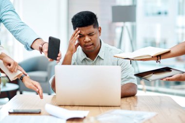 İş yerinde bunalmak verimliliğinize ve sağlığınıza zarar verebilir. Zorlu bir ofis ortamında stresli görünen genç bir işadamı.