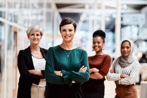 Self-confidence is the foundation of all great success and achievement. Portrait of a young businesswoman standing in an office with her colleagues in the background