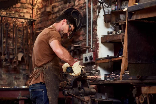 他把暖气调大了 在焊接车间工作时使用喷灯的年轻英俊金属工人 — 图库照片