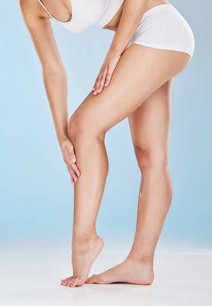 Woman, legs and skincare moisturizer of a model using lotion, cream and skin leg treatment. Beauty, cosmetic and well being health care of a person touching a body to feel smooth hair laser treatment.