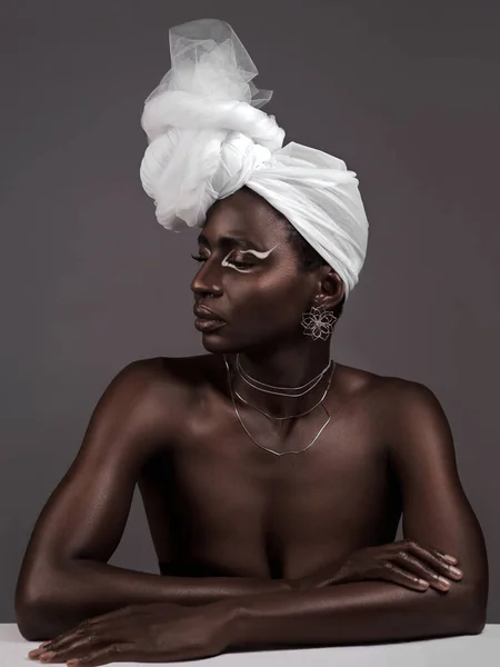 If it makes you feel like a queen, wear it. Studio shot of an attractive young woman posing in traditional African attire against a grey background