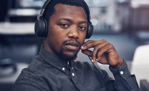 Ask me anything about architecture. Cropped portrait of a handsome young male architect wearing headphones while sitting in a modern office