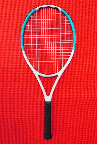 俺の選択の武器だ スタジオ内の赤い背景に置かれたテニスラケットの高い角度のショット — ストック写真
