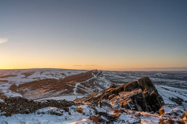 Hen Cloud, and The Roaches at sunrise during winter in the Peak District National Park.