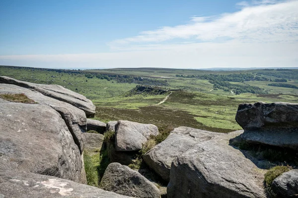 View of the ancient Iron Age hill fort Carl Wark from Higger Tor in the Peak District National Park, Derbyshire, UK.