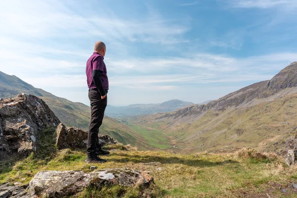 Stock image A walker admiring the view of Cwm Croesor from Cnicht, Gwynedd, Wales