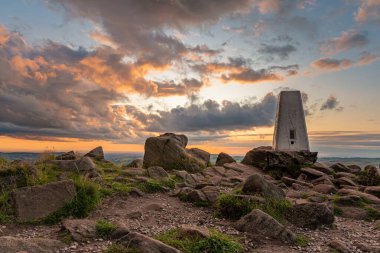 Hamamböceklerinin tepesindeki trigonometri noktası Peak District Ulusal Parkı 'nda gün batımında..