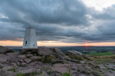 Hamamböceklerinin tepesindeki trigonometri noktası Peak District Ulusal Parkı 'nda gün batımında..