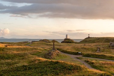 Llanddwyn Adası deniz feneri, Twr Mawr Anglesey 'deki Ynys Llanddwyn, Kuzey Galler' de gün batımında..