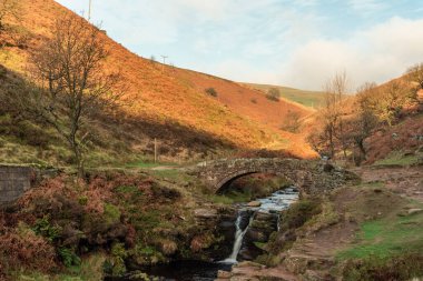 Peak District Ulusal Parkı 'ndaki Three Shires Head' de bir şelale ve yük atı taşı köprüsü..