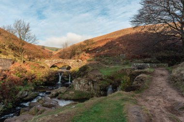 Peak District Ulusal Parkı 'ndaki Three Shires Head' de bir şelale ve yük atı taşı köprüsü..