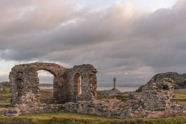 Anglesey, Kuzey Galler 'deki Ynys Llanddwyn' deki yıkılmış kilise ve Sakson haçı..