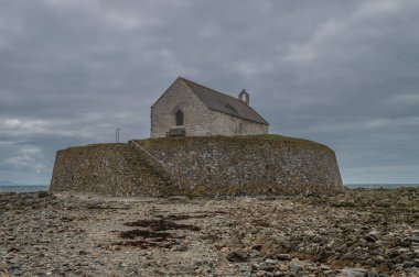 12. yüzyıl St Cwyfan Kilisesi, Anglesey 'deki küçük gelgit adası Cribinauon' da..