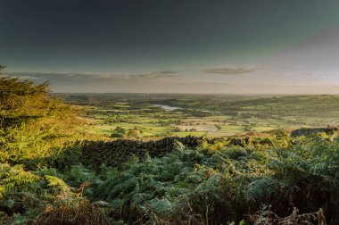 Güneş, Tittesworth Barajı 'nın ve Peak District Ulusal Parkı' ndaki hamamböceklerinin etrafındaki tarlaların üzerinde batıyor..