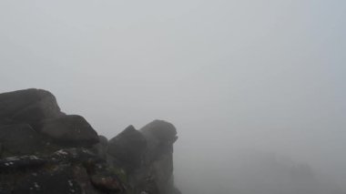Misty UK kış bozkırları Staffordshire Tepesi 'ndeki kayalara tırmanıyor..