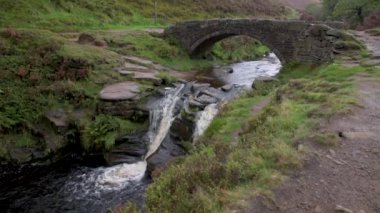 Üç Shire Heads. Sonbahar şelalesi ve taştan yük beygiri köprüsü Üç Shires Head in the Peak District.