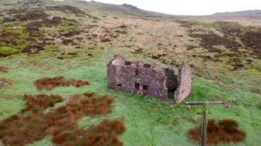 4K landscape drone footage. Abandoned barn and bleak moorland at The Roaches in the Peak District National Park, Staffordshire, UK.
