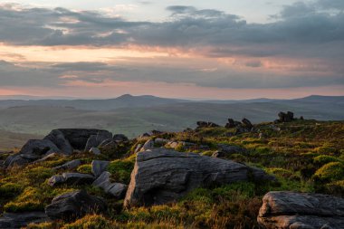 İngiltere 'nin Peak District Ulusal Parkı' ndaki Staffordshire, The Roaches 'ta kırsal bir manzaranın atmosferik günbatımı görüntüsü..