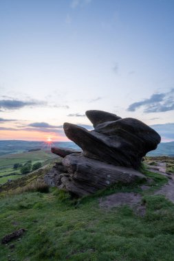 İngiltere 'nin Peak District Ulusal Parkı' ndaki Staffordshire, The Roaches 'ta kırsal bir manzaranın atmosferik günbatımı görüntüsü..