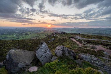 İngiltere 'nin Peak District Ulusal Parkı' ndaki Staffordshire, The Roaches 'ta kırsal bir manzaranın atmosferik günbatımı görüntüsü..