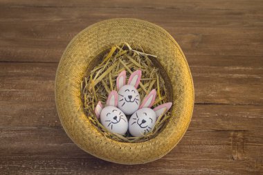 İçinde saman olan bir şapka ve Paskalya için süslü yumurtalar.
