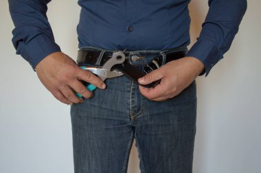 Bir adamın elleri yağlı olduğu için kemerinde bir delik daha açıyor..