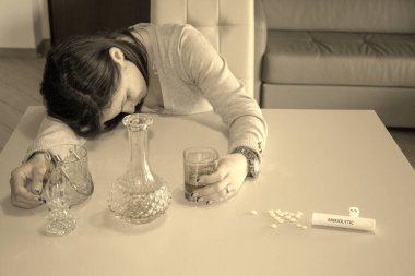 Uyuşturucu, uyuşturucu ve alkol kullandıktan sonra kafası masada dinlenen bir kadının görüntüsü. 